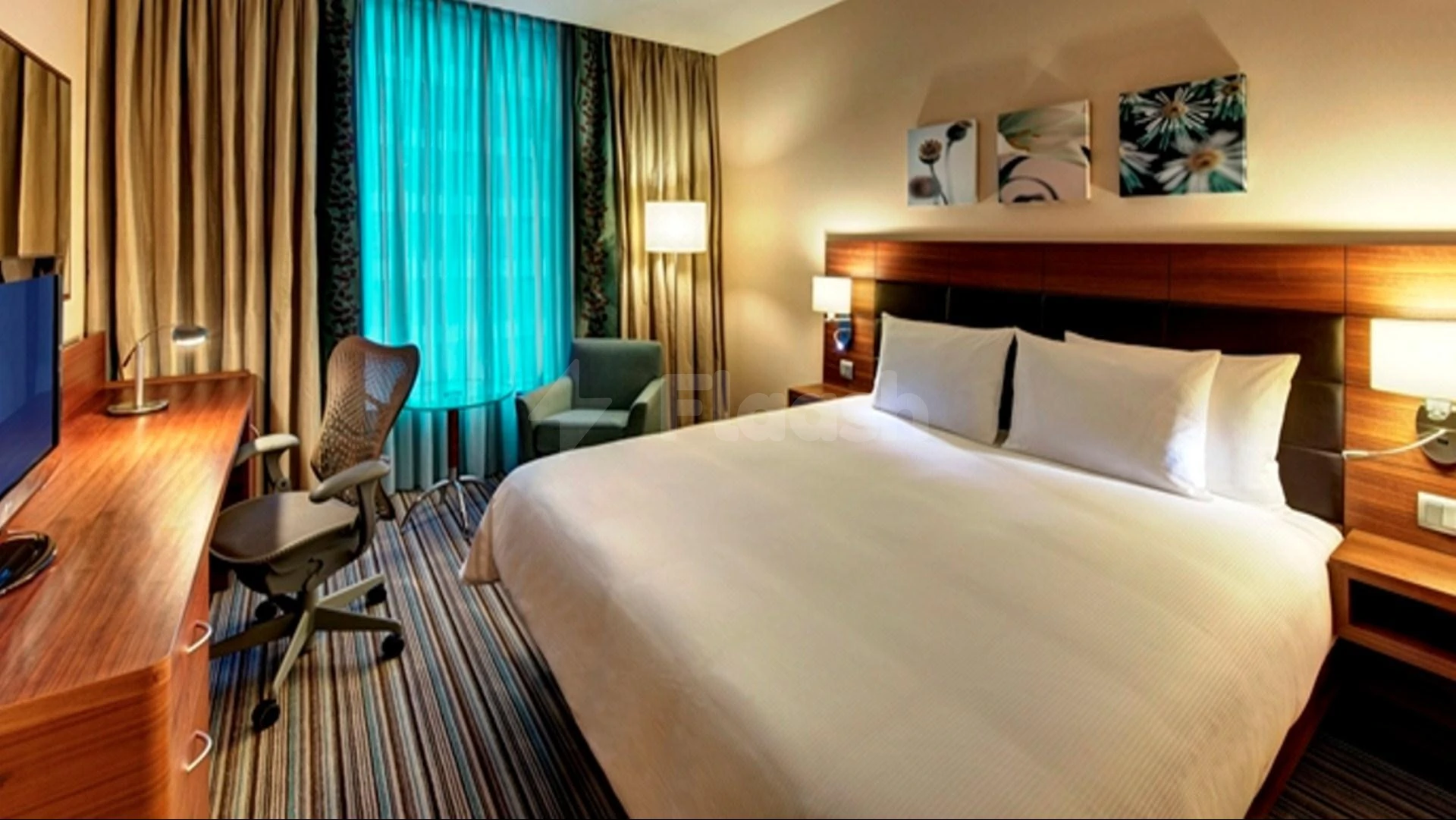 Guest room at Hilton Garden Inn Al Khobar, Al Khobar, featuring turquoise drapes and wooden headboard with floral