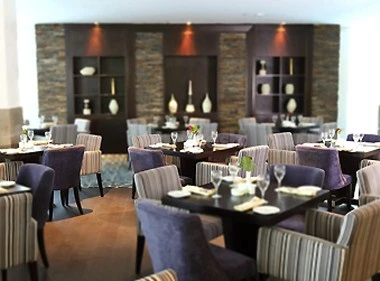 Dining area at Novotel Dammam Business Park, Dammam, with modern tables set for guests