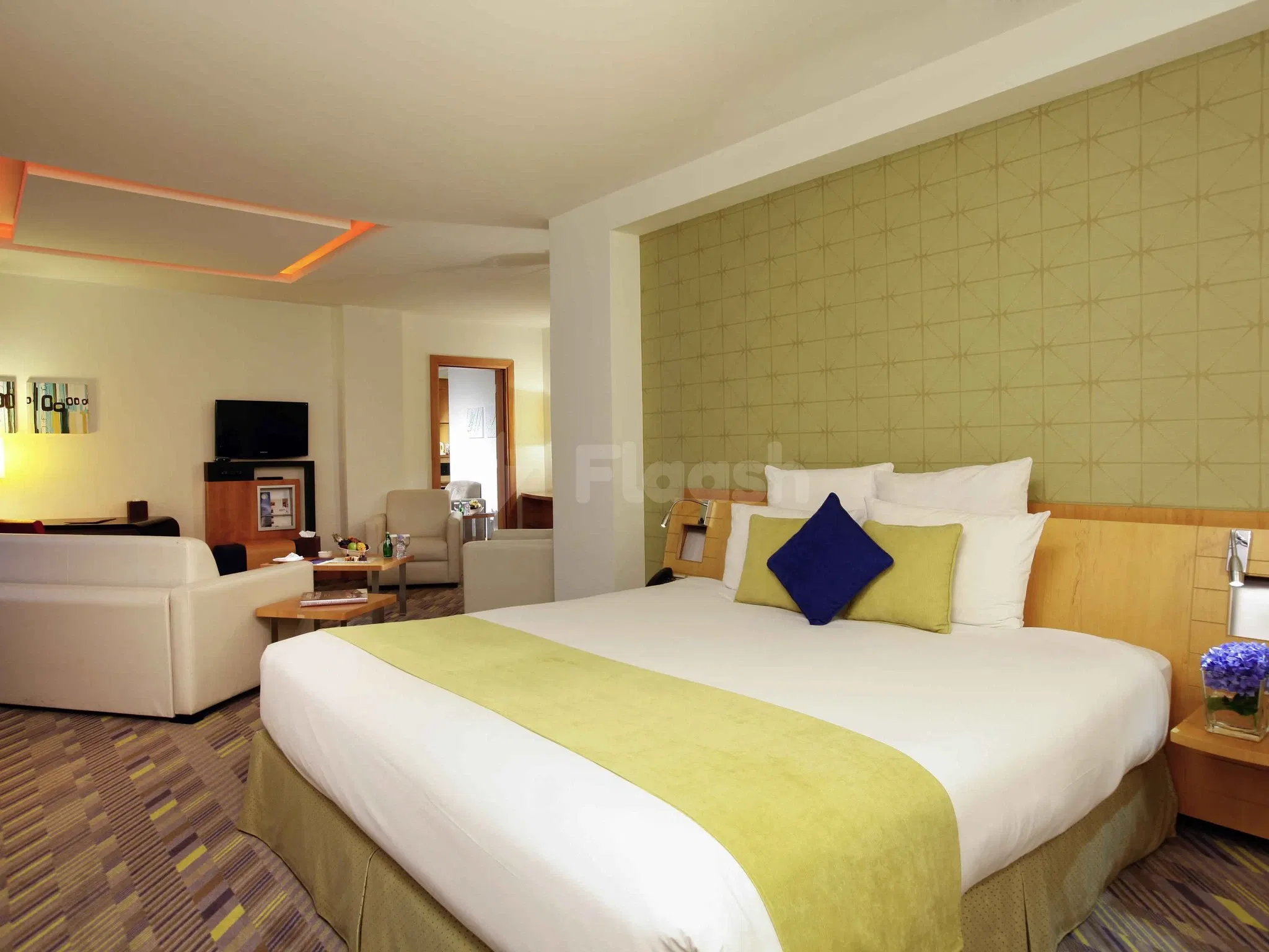 Guest room at Novotel Dammam Business Park, Dammam, featuring green accent wall and patterned carpeting