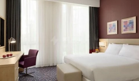 Guest room at Radisson Blu Residence, Dhahran, featuring purple walls and modern artwork above bed