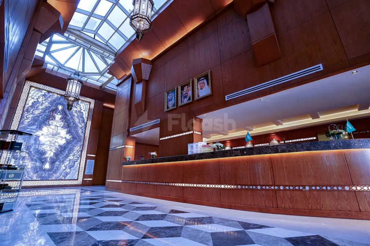 Grand lobby at Vivid Jeddah Hotel, Jeddah, featuring geometric marble flooring and a large illuminated mosaic wall