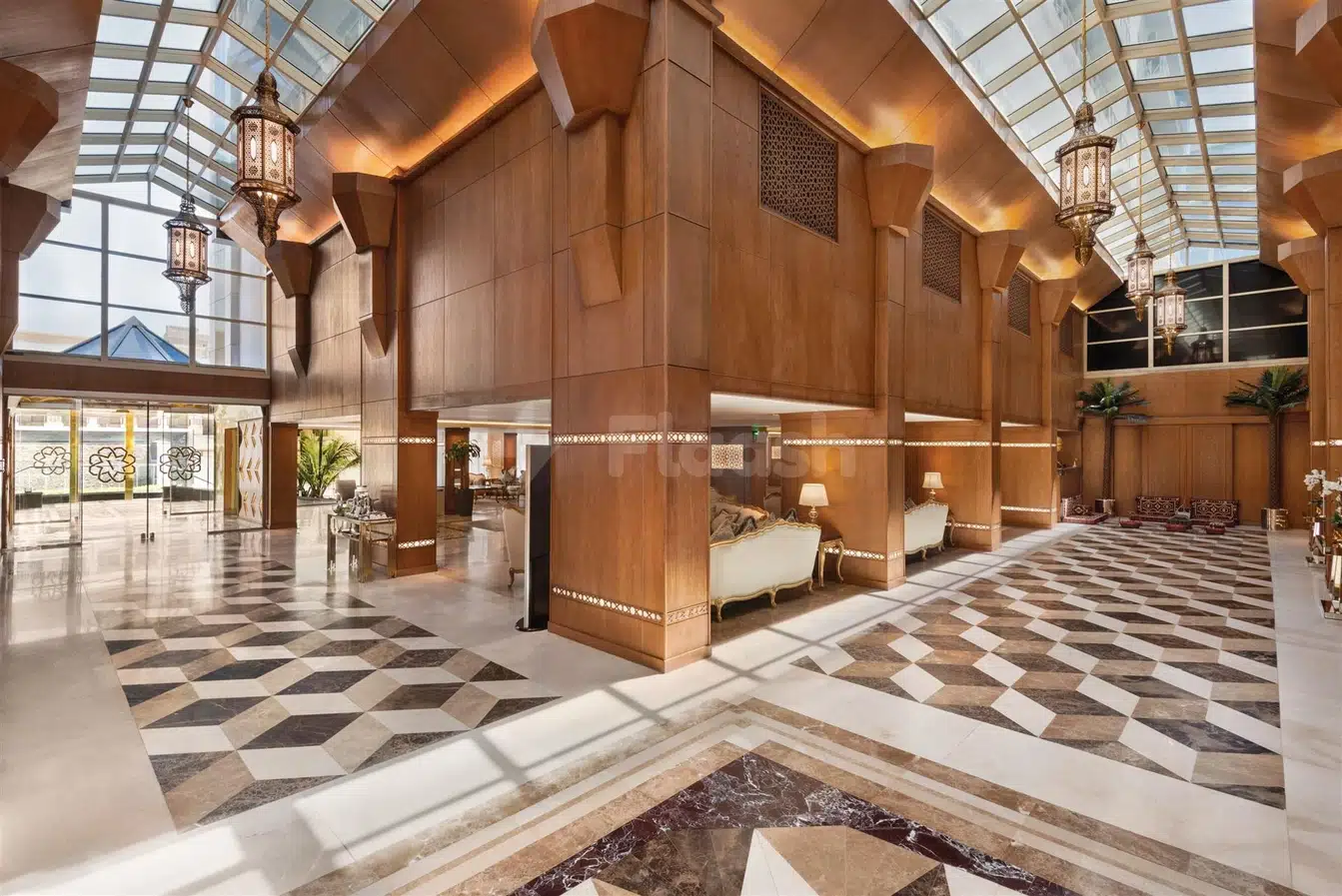 Grand lobby at Vivid Jeddah Hotel, Jeddah, featuring geometric marble flooring and ornate lanterns under a glass ceiling