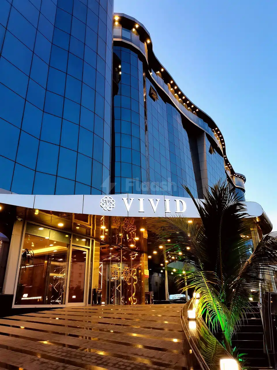 Modern glass facade at Vivid Jeddah Hotel, Jeddah, with illuminated entrance signage