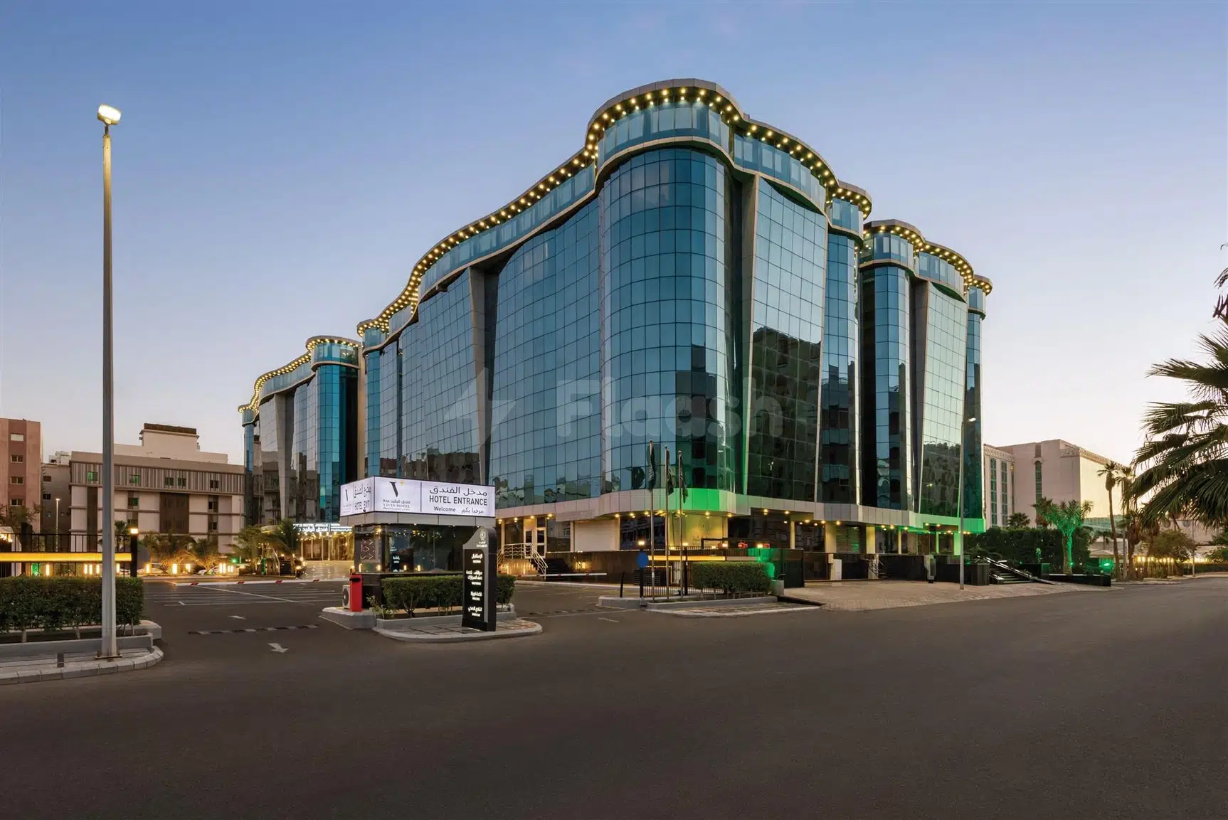 Modern glass facade hotel at Vivid Jeddah Hotel, Jeddah, with illuminated roofline and entrance canopy