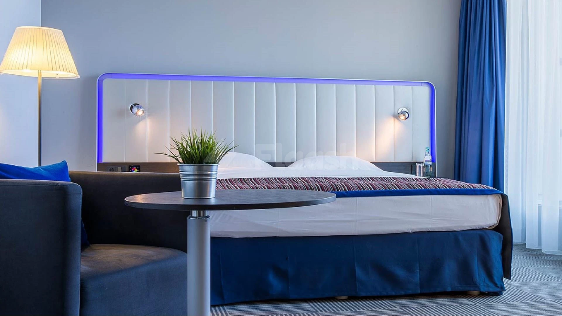 Bedroom at Park Inn by Radisson, Najran, Najran, with blue upholstered headboard and ambient lighting