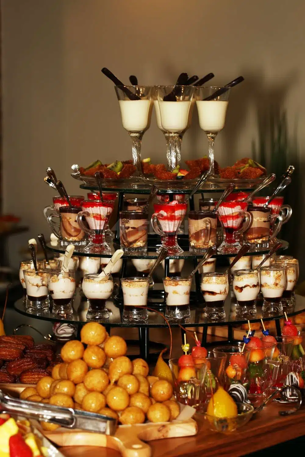 Dessert buffet at Park Inn by Radisson, Najran, Najran, featuring layered glass cups with spoons and fruit garnishes