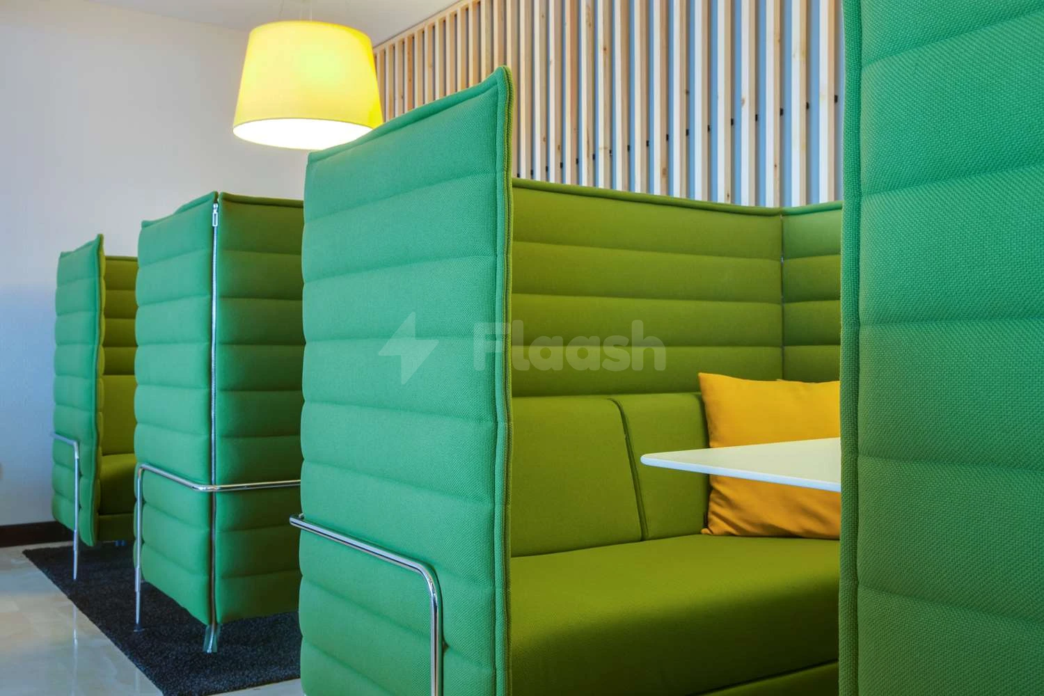 Lounge seating at Park Inn by Radisson Dammam, Dammam, with vibrant green booths and yellow pendant lights