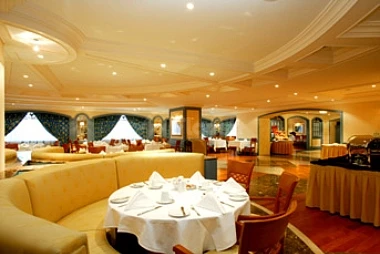 Dining room at Le Méridien Makkah, Makkah, featuring round tables with white linens and warm ambient lighting