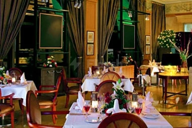Dining room at Sheraton Dammam Hotel & Convention Centre, Dammam, with tables set with floral centerpieces and red wine