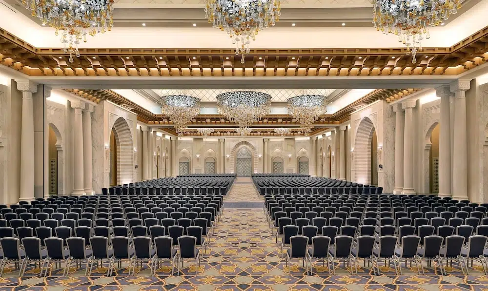 Ballroom at Hilton Hotel & Convention Jabal Omar Makkah, Makkah, with rows of chairs and ornate chandeliers above marble