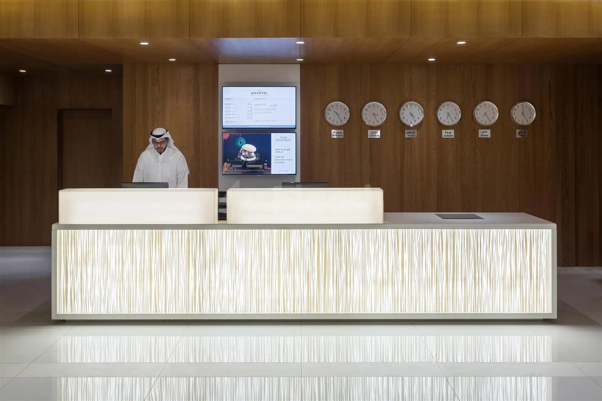 Reception area at Novotel Jeddah Tahlia Street found in Jeddah featuring wooden paneling and multiple wall clocks