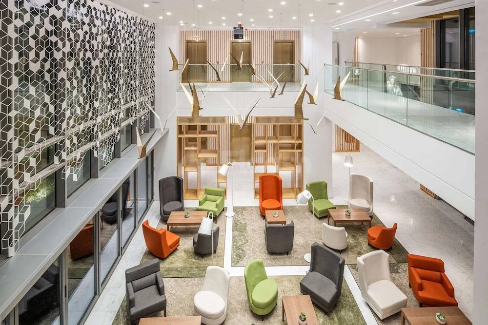 Lobby at Park Inn Hotel - By Radisson Riyadh, featuring geometric wall tiles and colorful modular seating areas