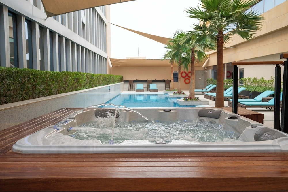 Outdoor jacuzzi at Park Inn Hotel - By Radisson Riyadh, Riyadh, surrounded by palm trees and wooden decking near
