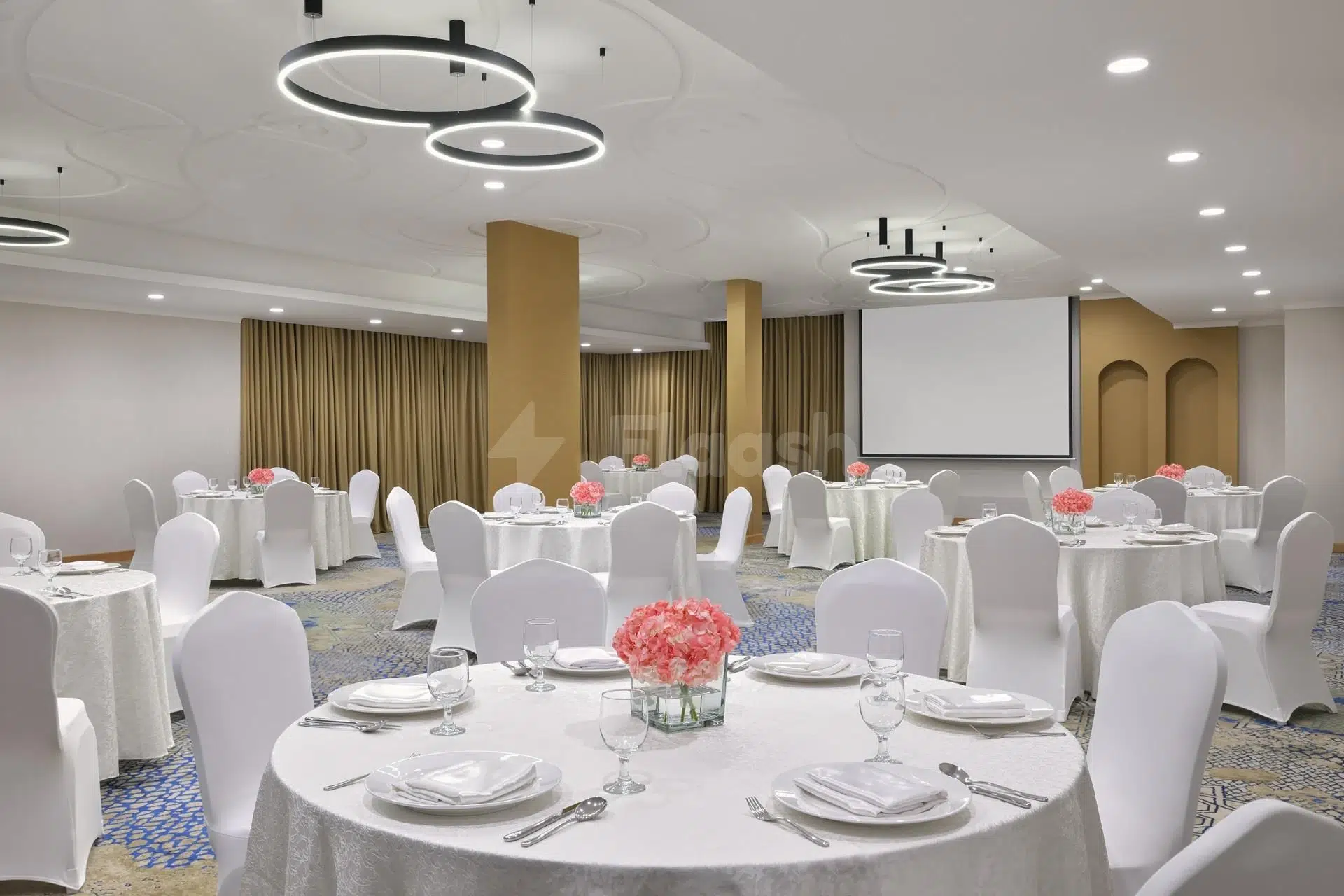 Banquet hall at Holiday Inn Jeddah Corniche, Djeddah, with circular pendant lights and white table settings