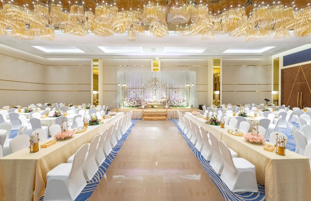 Banquet hall at Radisson Blu Hotel, Jeddah Al Salam, with golden chandeliers and floral stage backdrop