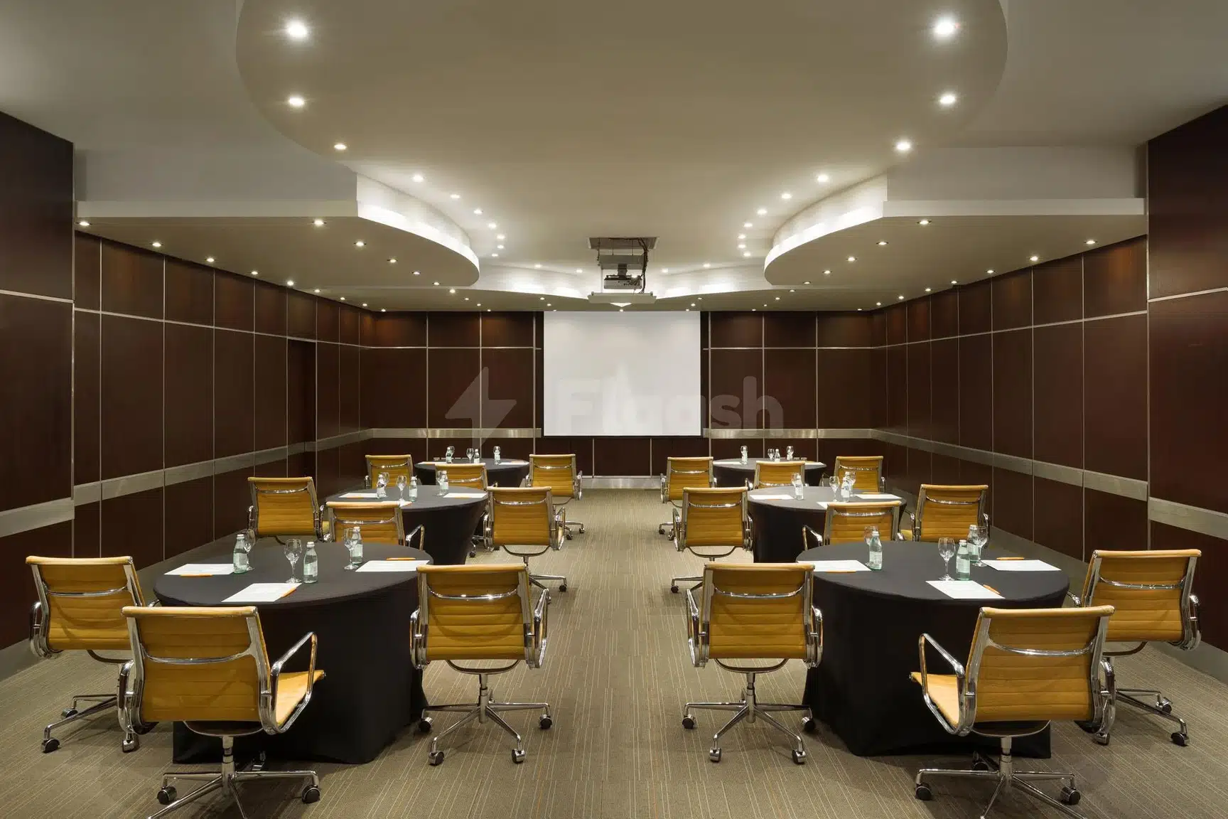 Conference room at Crowne Plaza Al, Al Khobar, with wooden chairs and dark paneling under recessed ceiling lights