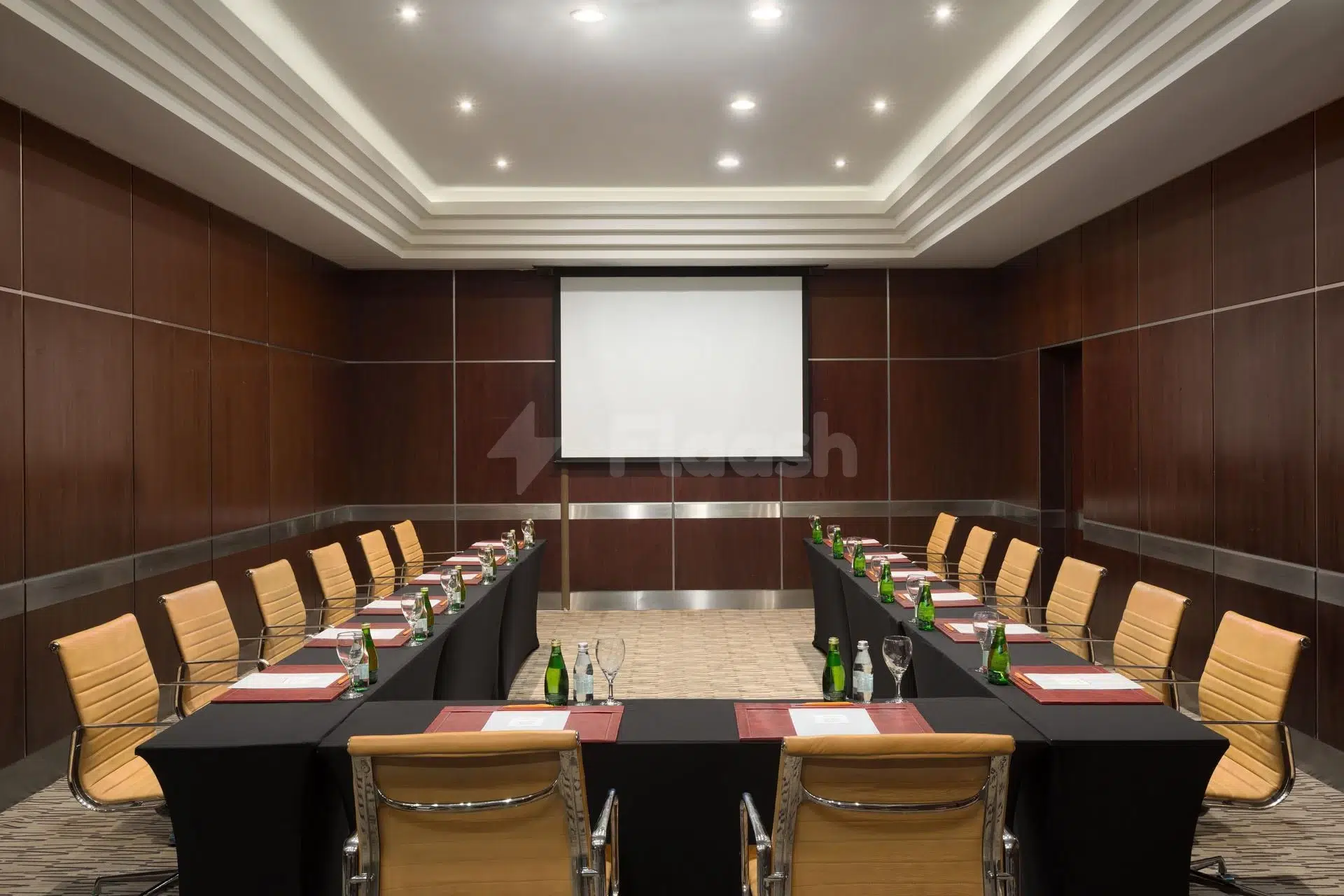 Conference room at Crowne Plaza Al Kh347, Al Khobar, with dark wood paneling and central projector screen