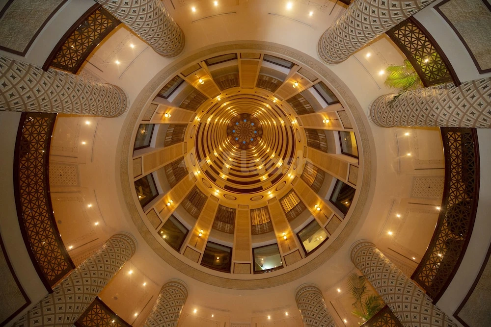 Grand atrium at Rosewood Jeddah, Jeddah, featuring a golden dome ceiling and patterned columns