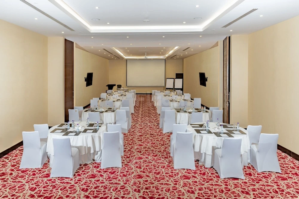 Banquet hall at Courtyard by Marriott Riyadh Olaya, Riyadh, with white-draped tables on red patterned carpet and large