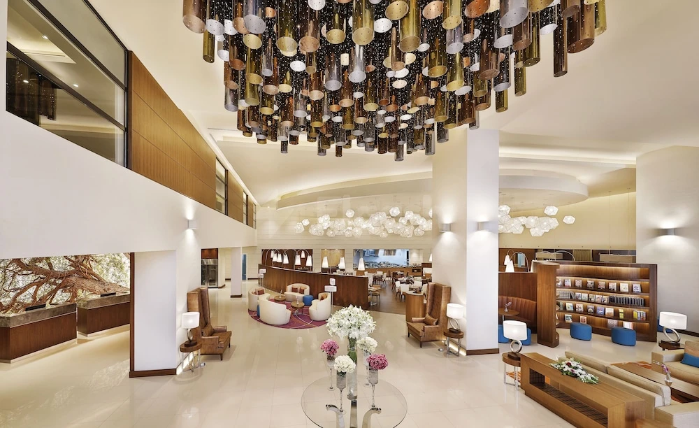 Lobby at Courtyard by Marriott Riyadh Olaya, Riyadh, featuring a cascading metallic chandelier and modern seating areas