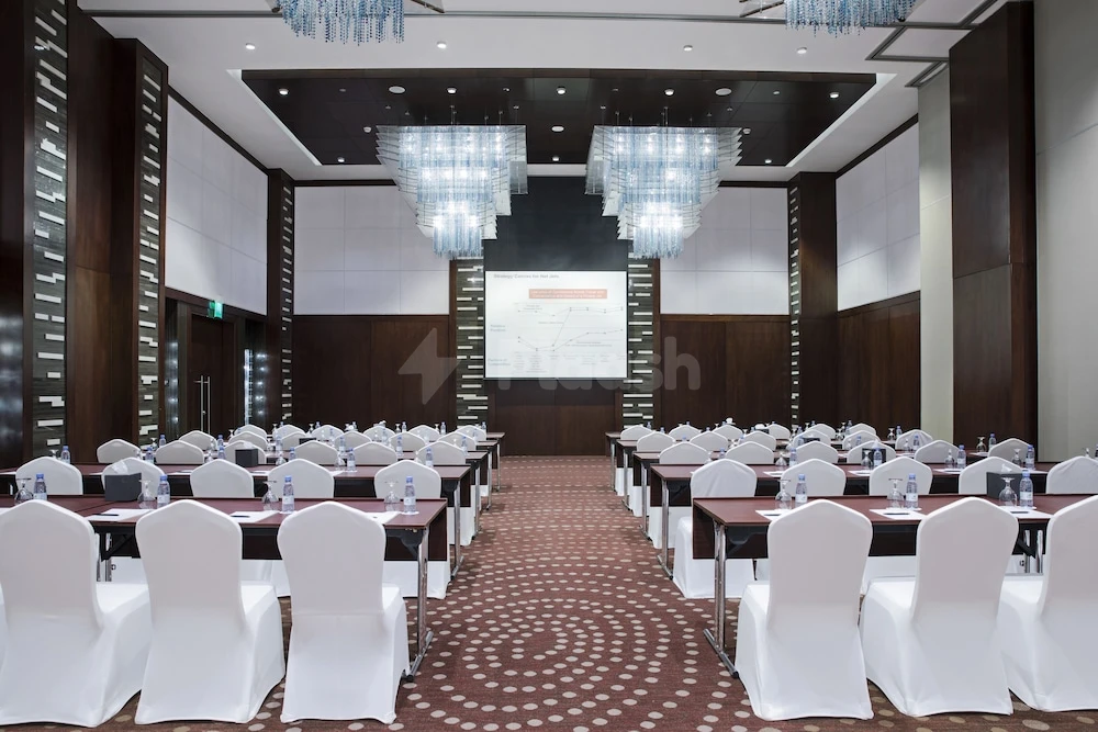 Conference hall at Rosh Rayhaan By Rotana, Riyadh, with crystal chandeliers and patterned carpeting