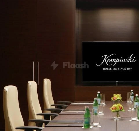 Boardroom at Kempinski Al Othman Hotel, Al Khobar, with branded screen and floral centerpieces on polished table