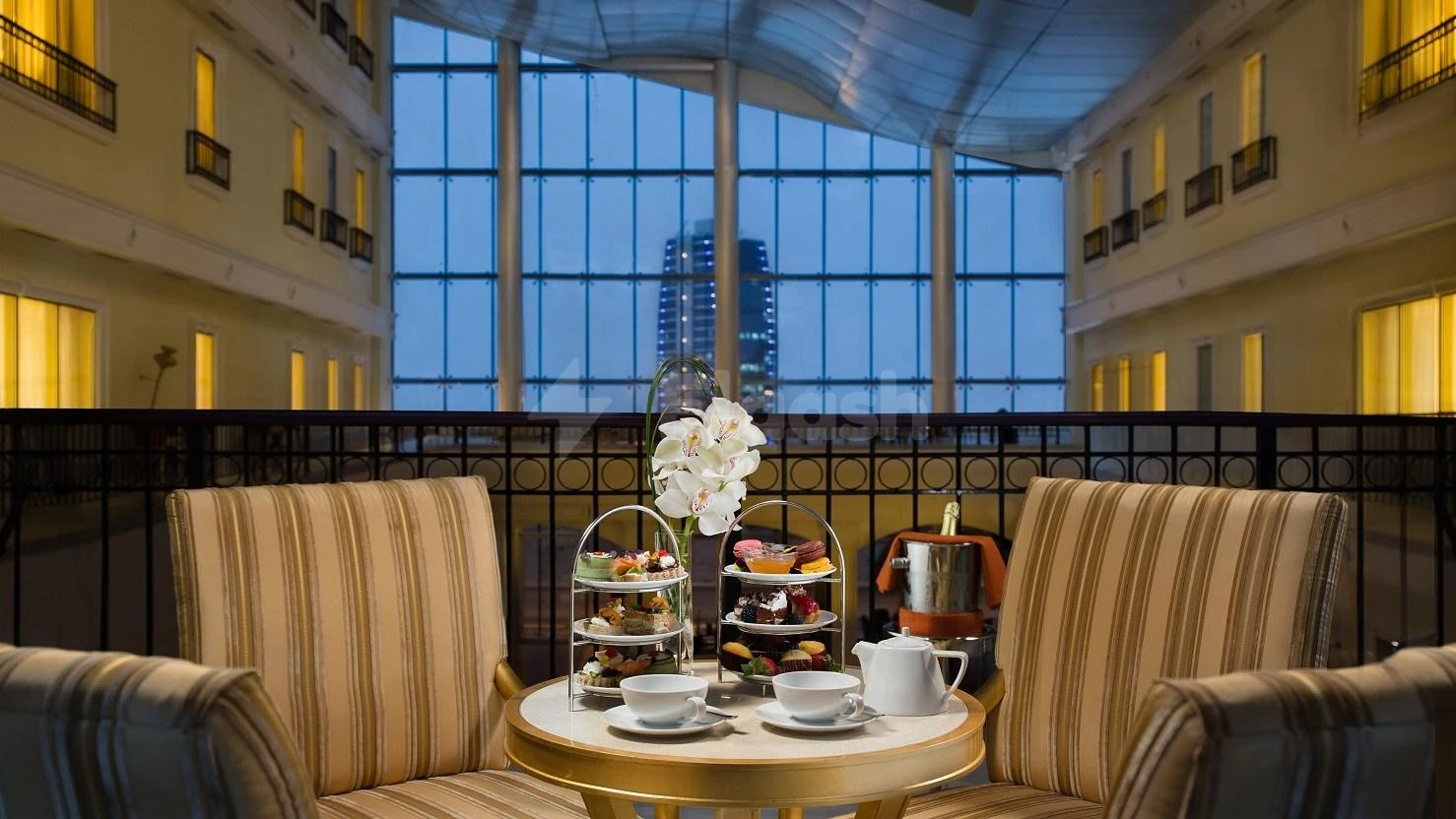 Lobby lounge at Kempinski Al Othman Hotel, Al Khobar, with high arched windows and city skyline view