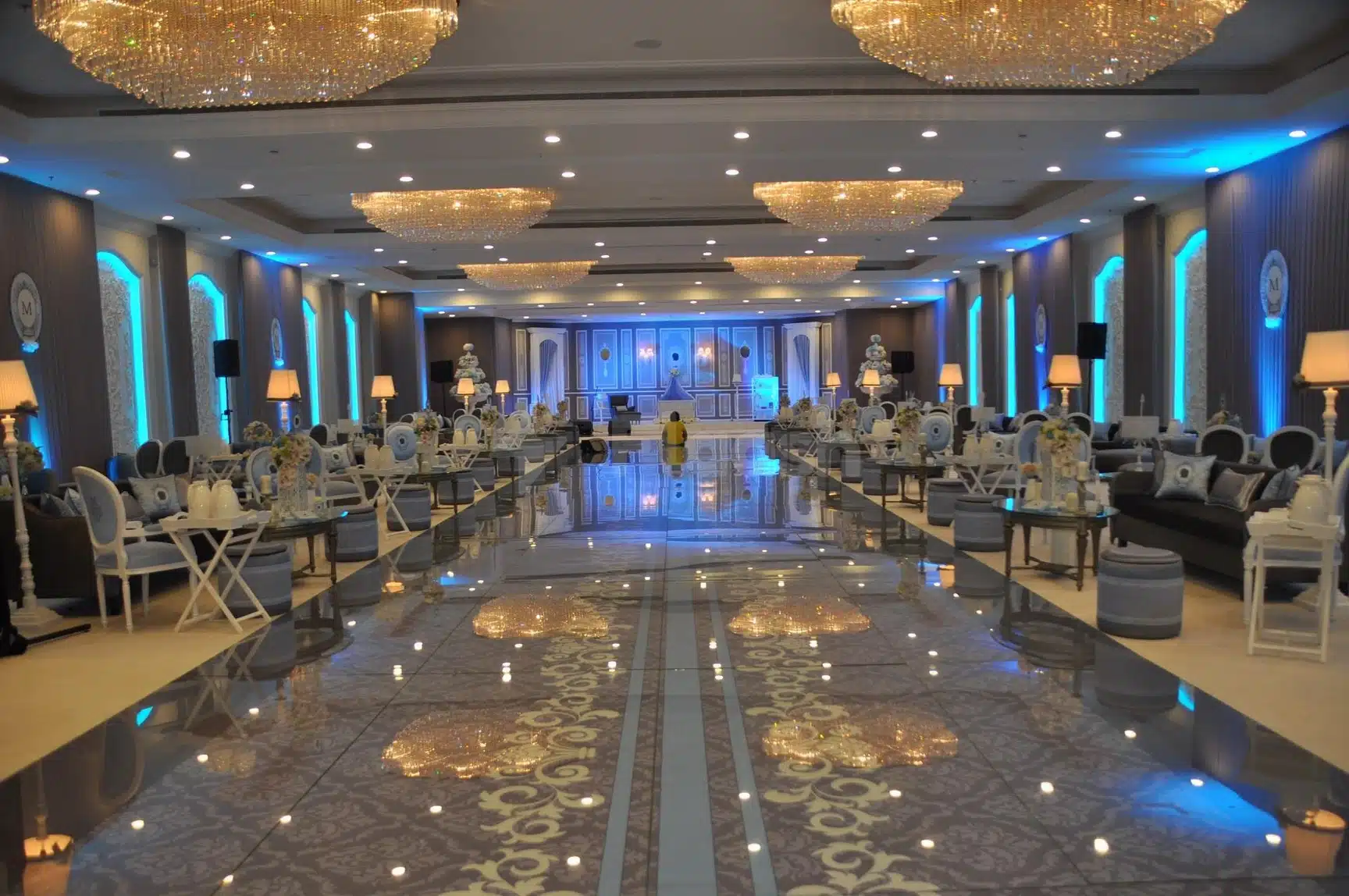 Ballroom at Crowne Plaza Riyadh Al Waha, Riyadh, with crystal chandeliers and reflective marble floors illuminated by blue