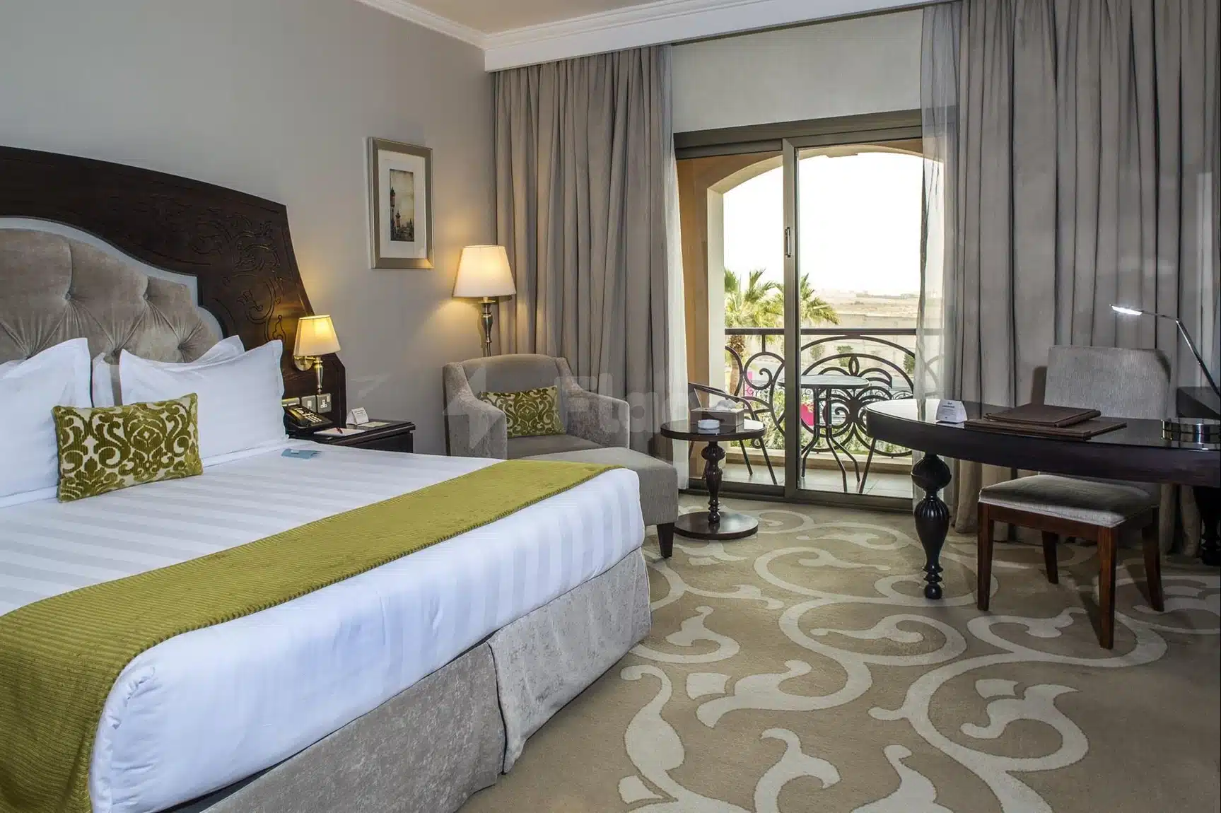 Guest room at Crowne Plaza Riyadh Al Waha, Riyadh, featuring patterned carpet and balcony view