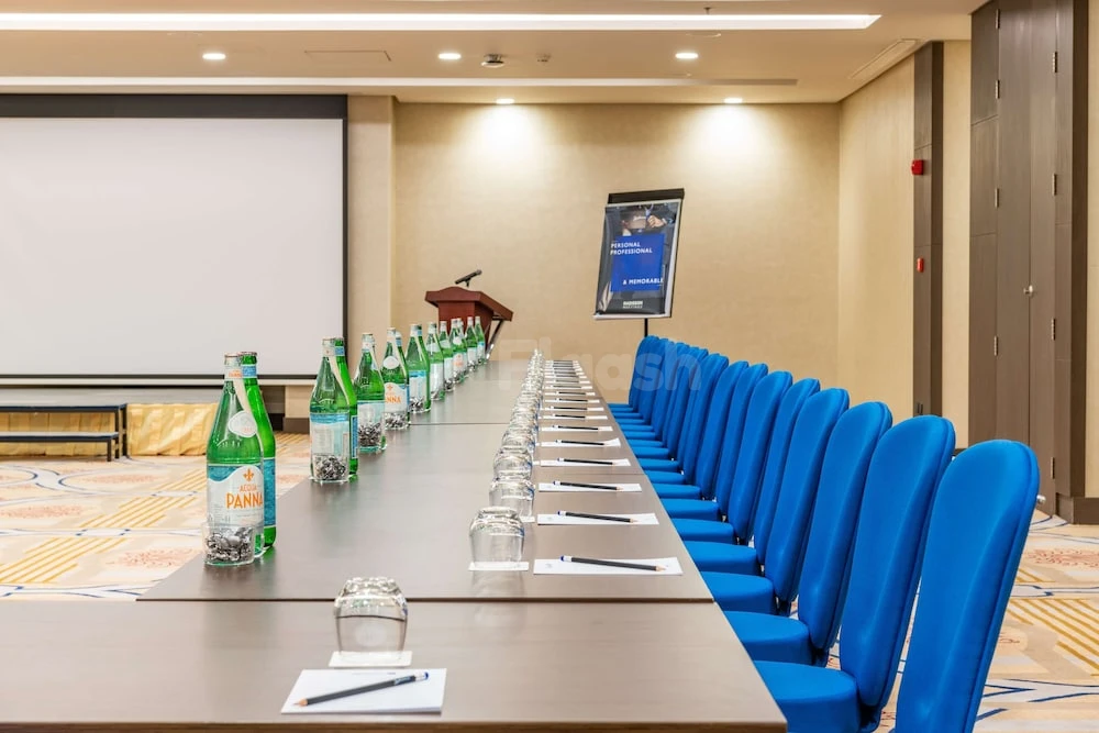 Conference room at Radisson Blu Hotel, Jeddah Corniche, Jeddah, with blue chairs and bottled water arranged along