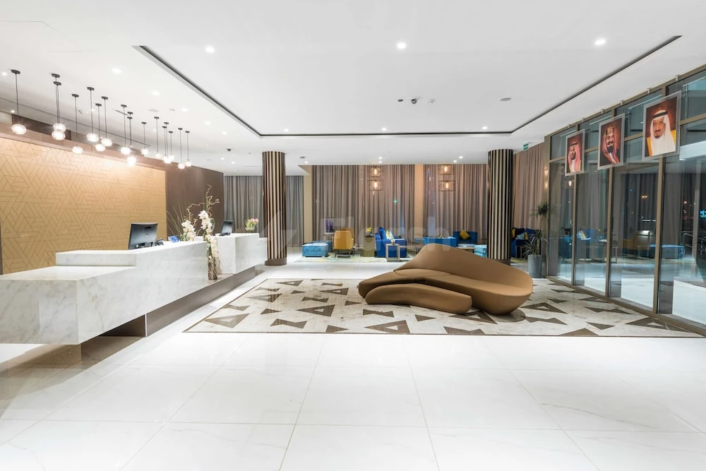 Marble lobby at Radisson Blu Hotel, Jeddah Corniche, with modern pendant lights and sculptural brown lounge chair