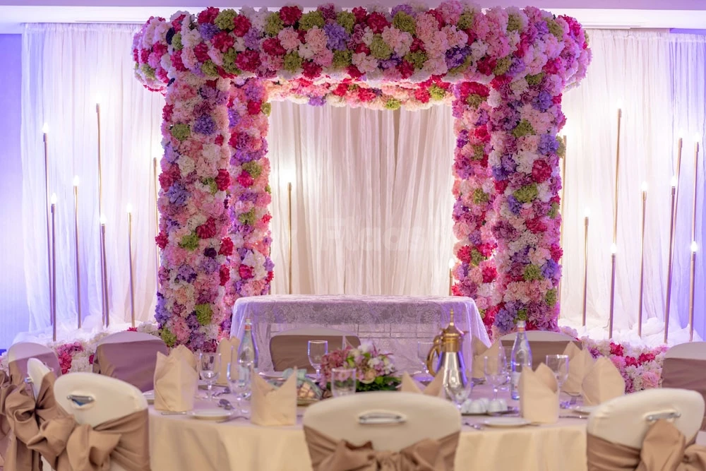 Wedding reception space at Radisson Blu Hotel, Jeddah Corniche, with floral arch and candlelit tables