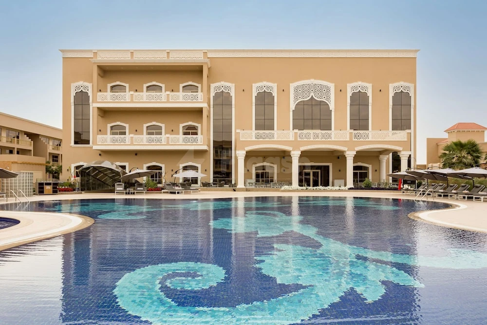 Outdoor pool at Radisson Hotel Riyadh Airport, Riyadh, featuring mosaic design and arched balconies