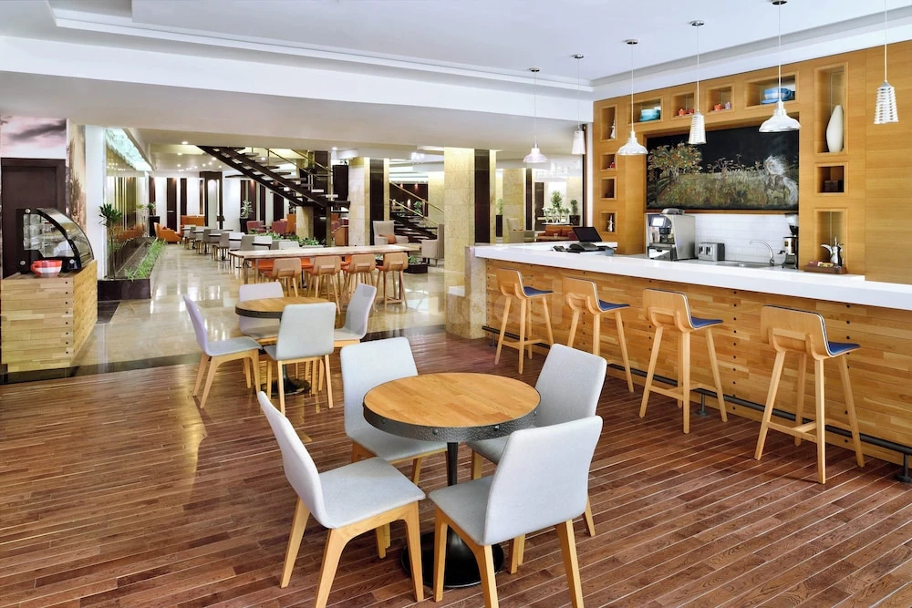 Dining area at Four Points by Sheraton Riyadh Khaldia, Riyadh, with wooden floors and bar seating