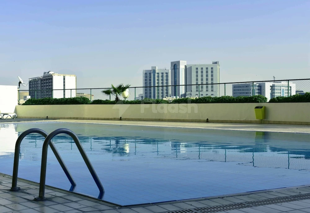 Rooftop pool at Four Points by Sheraton Riyadh Khaldia, Riyadh, with city skyline view beyond fence and metal