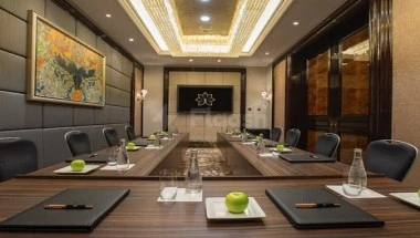 Boardroom at Narcissus Hotel & Residence Riyadh, Riyadh, featuring a long wooden table with green apples and black folders
