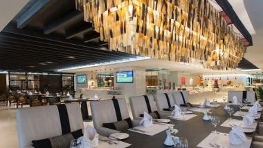 Dining area at Narcissus Hotel & Residence Riyadh, featuring modern chandeliers and sleek table settings