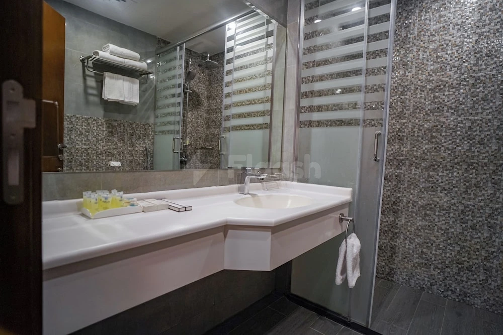Bathroom at Emaar Elite Makkah Hotel, Makkah, featuring mosaic tile walls and glass shower enclosure