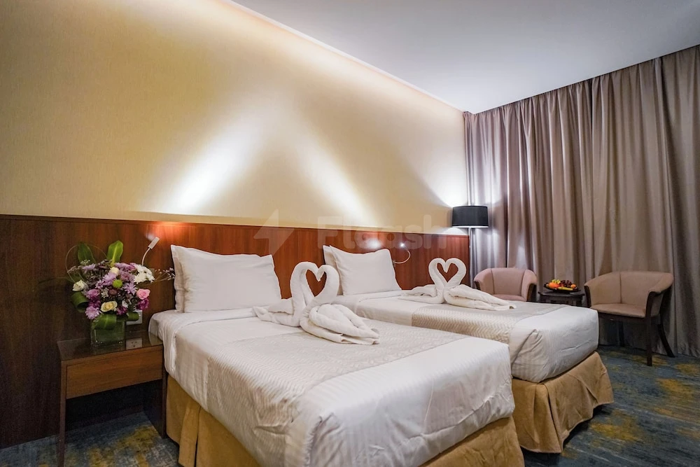 Guest room at Emaar Elite Makkah Hotel, Makkah, with swan towel art and wooden headboard