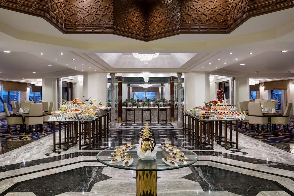 Buffet lounge at Makkah Hotel, Makkah, featuring marble floors and geometric ceiling patterns with golden accents and tiered