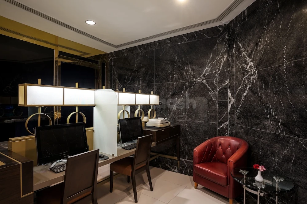 Business lounge at Makkah Hotel, Makkah, featuring black marble walls and a red leather armchair with glass side