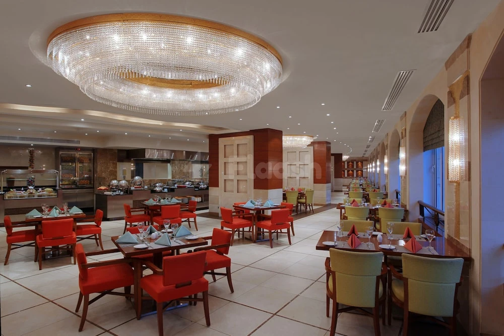 Dining hall atarges at M Tits Makkah Hotel, Makkah, Coffe with large crystal chandelier and red seating areas