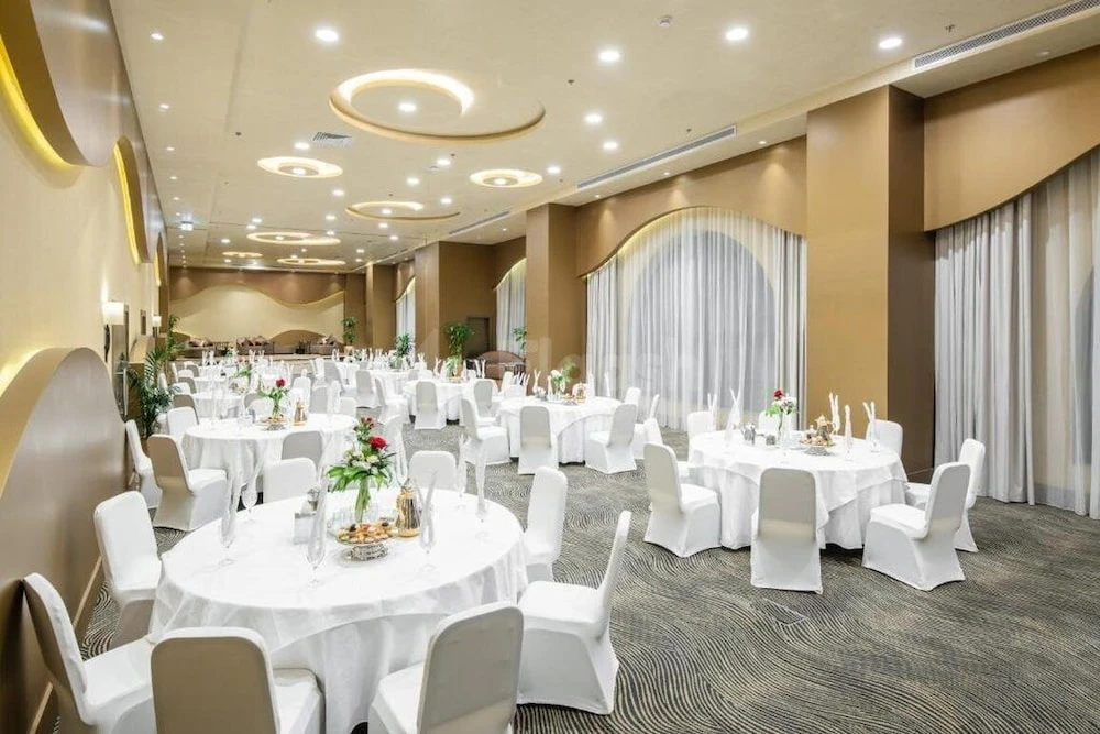 Banquet hall at Copthorne Makkah Al Naseem, Makkah, with circular ceiling lights and white draped tables