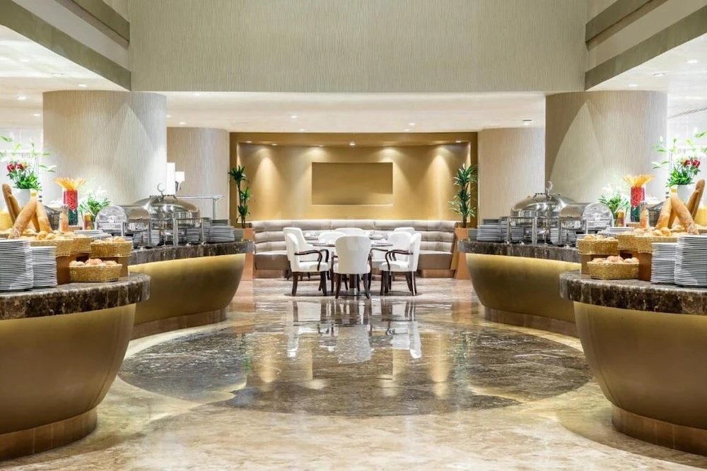 Buffet area at Copthorne Makkah Al Naseem, Makkah, with golden counters and marble flooring
