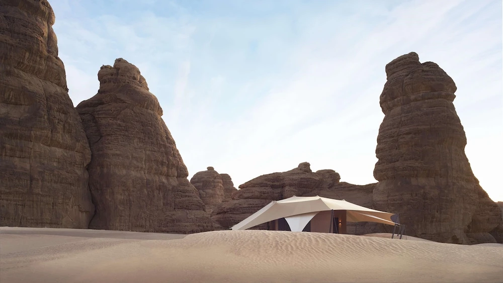 Desert tent at Banyan Tree AlUla, AlUla, nestled among towering sandstone rock formations under a clear sky