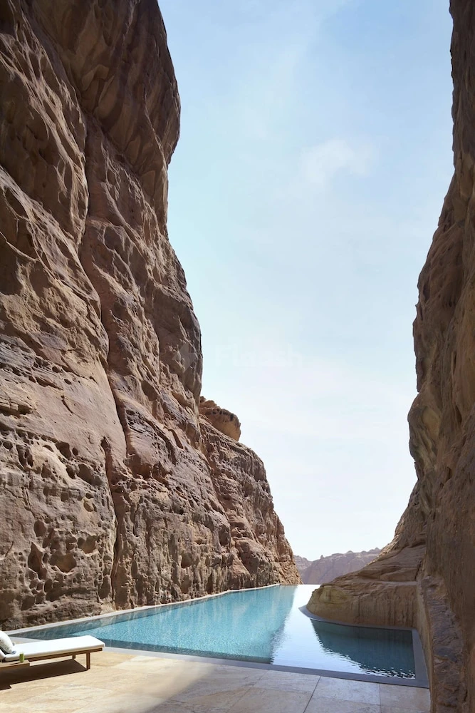 Infinity pool at Banyan Tree AlUla, AlUla, nestled between towering sandstone cliffs under a clear sky