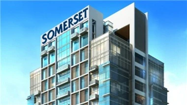 Modern glass building at Somerset Downtown Al Khobar, Al Khobar, with prominent blue signage on top floor