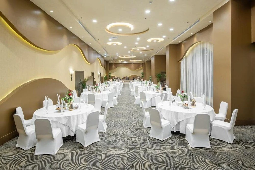 Banquet hall at Copthorne Makkah Al Naseem, Mecca, with wave-shaped walls and circular ceiling lights