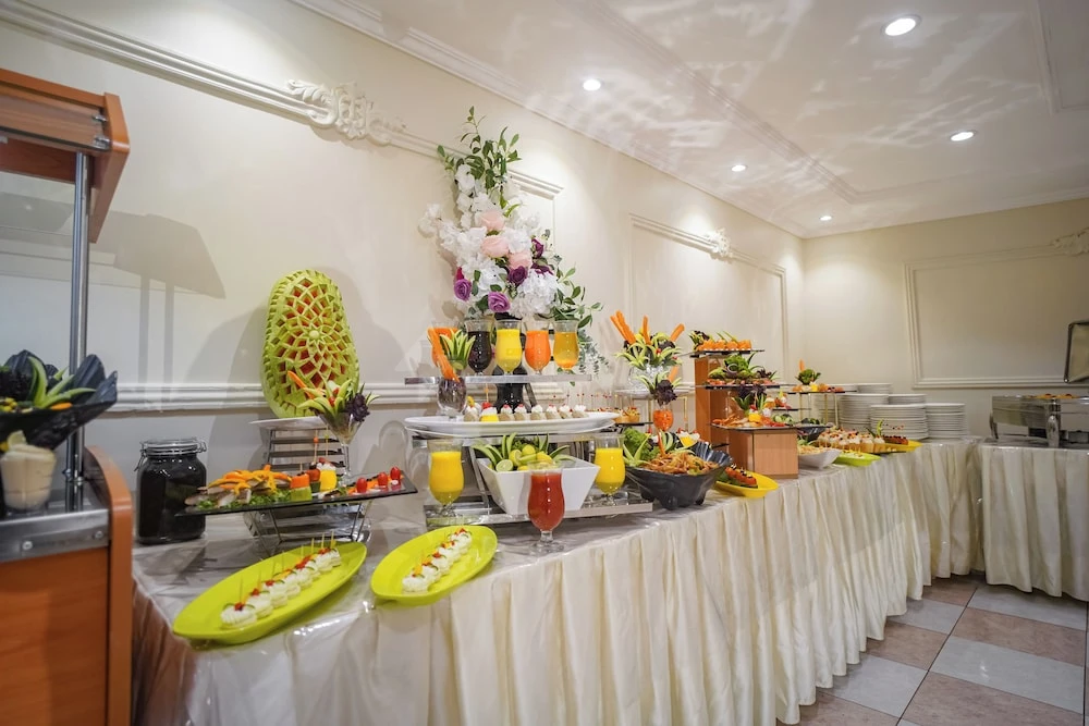 Buffet spread at Emaar Al Manar Hotel, Makkah, featuring tropical fruit arrangements and colorful drink displays