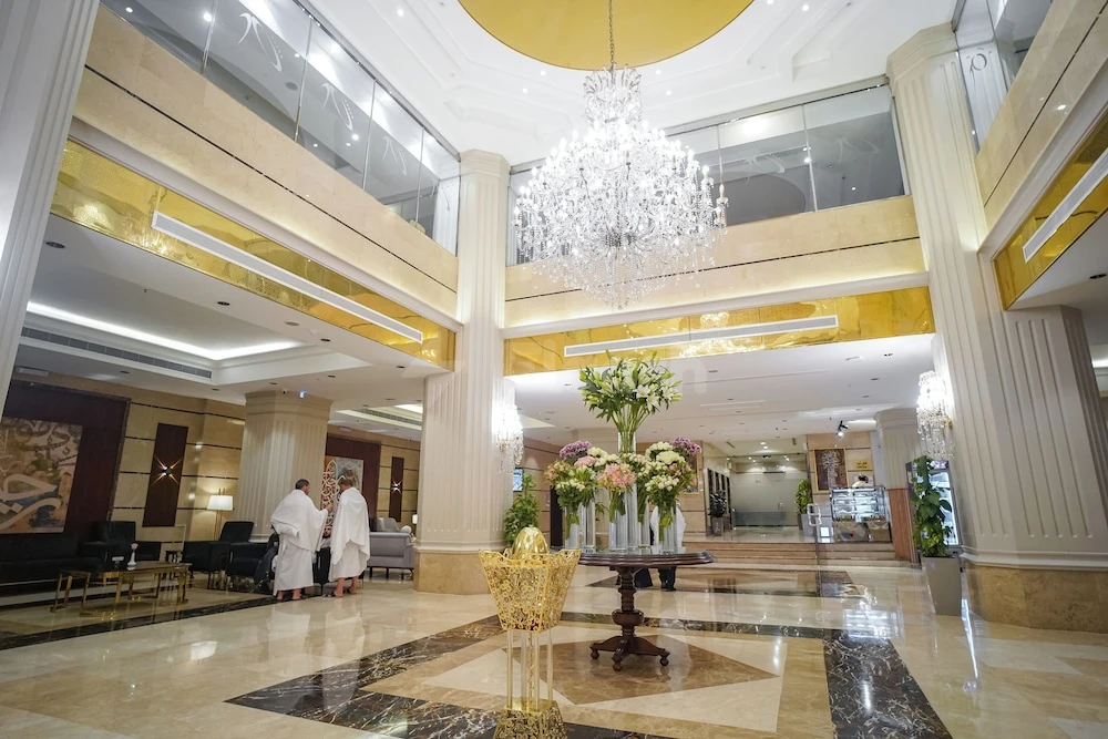 Grand marble lobby at Emaar Al Manar Hotel, Makkah, featuring a crystal chandelier and golden accents